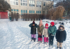 Dzieci na śniegu stoją.