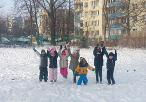 Dzieci cieszą se unosząc w górę ręce.