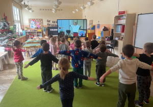 grupa dzieci unosi ręce do boku