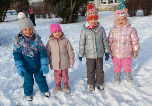 czworo dzieci stoi na śniegu