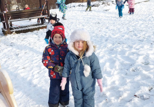 dwoje dzieci stoi na śniegu