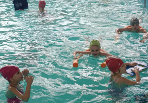 dzieci pływają w wodzie