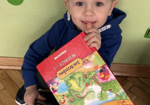 chłopiec trzyma w ręce książkę