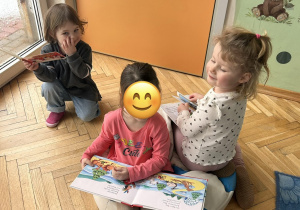 dziewczynki oglądają książeczki