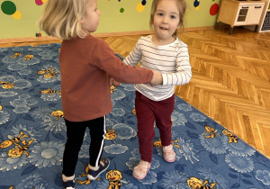 dwie dziewczynki tańczą w kółeczku