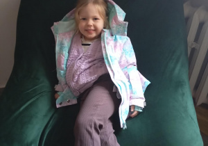 Dziewczynka siedzi na pufie