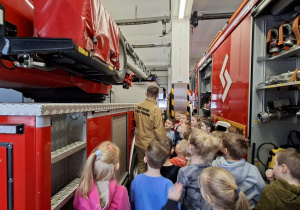 Dzieci ze strażakiem między wozami