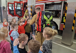 Dzieci otaczają strażaka