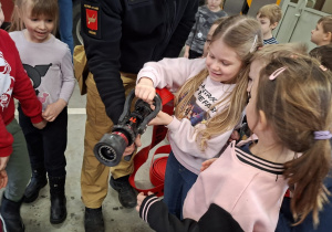 Dziewczynka trzyma prądownicę strażacką