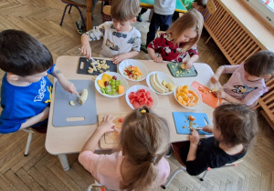 dzieci kroją owoce