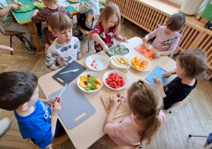 dzieci kroją owoce