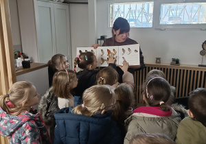 Pani fryzjerka pokazuje dzieciom próbki odcieni włosów