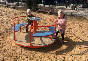 dziewczynka z chłopcem kręcą się na karuzeli