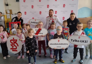 Dzieci pozują do zdjęcia z piłkarzami