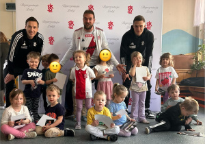 Dzieci pozują do zdjęcia z piłkarzami