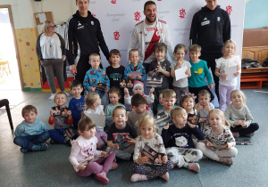 Dzieci pozują do zdjęcia z piłkarzami