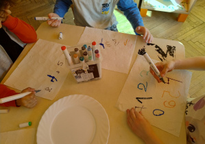 dzieci piszą cyfry mazakami