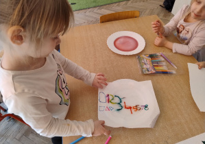 dziewczynka kładzie papier na wodę