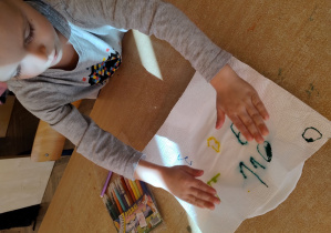 chłopiec układa ręcznik papierowy ze swoimi napisanymi cyframi