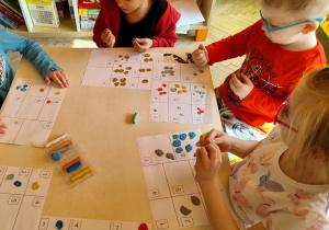 dzieci przyklejają kropki z plasteliny w odpowiedniej liczbie