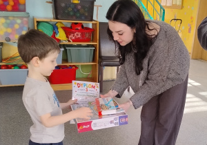 nauczycielka wręcza nagrody chłopcu