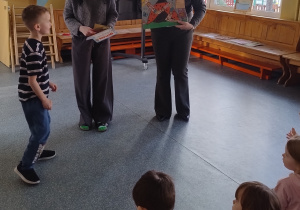 chłopiec podchodzi po nagrodę do pań