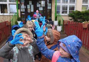 Dzieci idą w parach z rękawiczką na dłoni