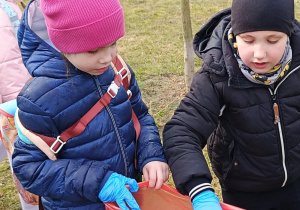 dzieci wrzucają odpady do worka