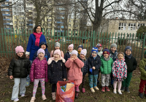 dzieci z panią i workiem z odpadami