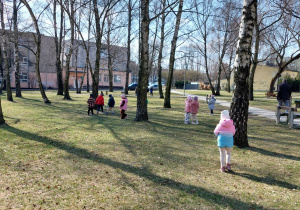 dzieci szukają odpadów na trawniku