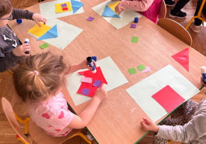 dzieci układają domek z figur geometrycznych