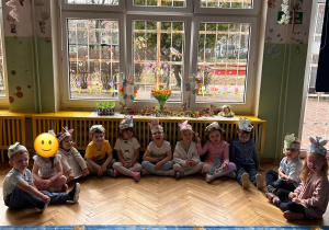 dzieci siedzą w półkolu