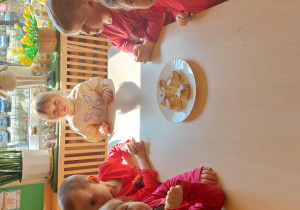 dzieci siedzą przy stole z pokrojonym ciastem z jabłkami