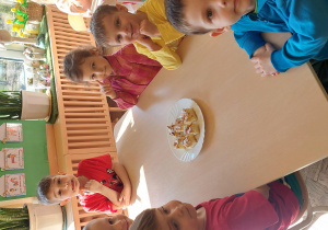 dzieci czekają przy stole na spożywanie ciasta