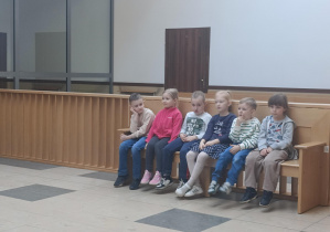 sześcioro dzieci siedzi na ławie