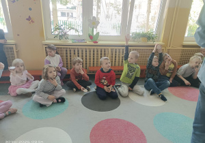 dzieci siedzą na dywanie