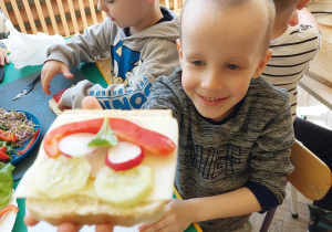 chłopiec trzyma w rękce kanapkę