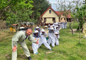dzieci pozują do zdjęcia w strojach pszczelarskich
