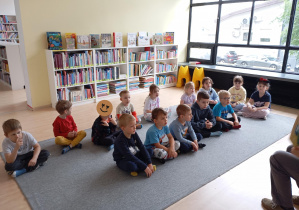 grupa dzieci siedzi na dywanie