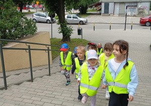 dzieci w kamizelkach odblaskowych wchodzą po schodach