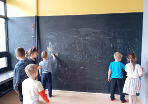 dzieci rysują kredą po tablicy