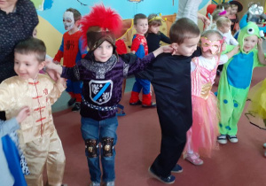 dzieci trzymają sie za uszy i tańczą