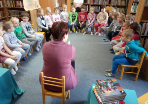 dzieci siedzą w kręgu z panią bibliotekarką