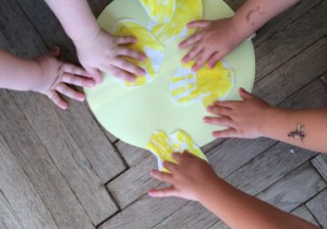 dłonie dzieci na żółtym kole