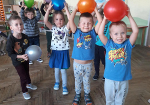 grupa dzieci trzymające nad głową kolorowe balony