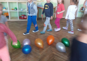 dzieci maszerują wokół balonów