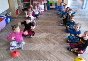 dzieci siedzą w dwóch rzędach - chłopców i dziewczynek