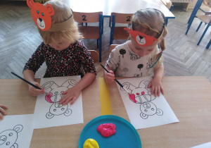 Dzieci siedzą przy stoliku i malują