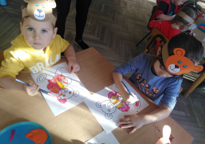 Dzieci siedzą przy stoliku i malują