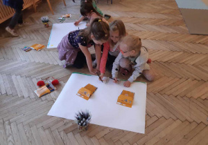 grupki dziewczyn rysują na dużych kartonach